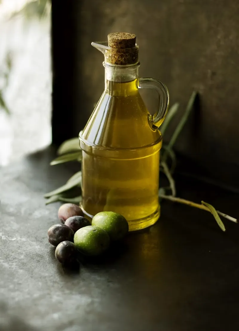 A cruet of our estate extra virgin olive oil with fresh olives and an olive branch
